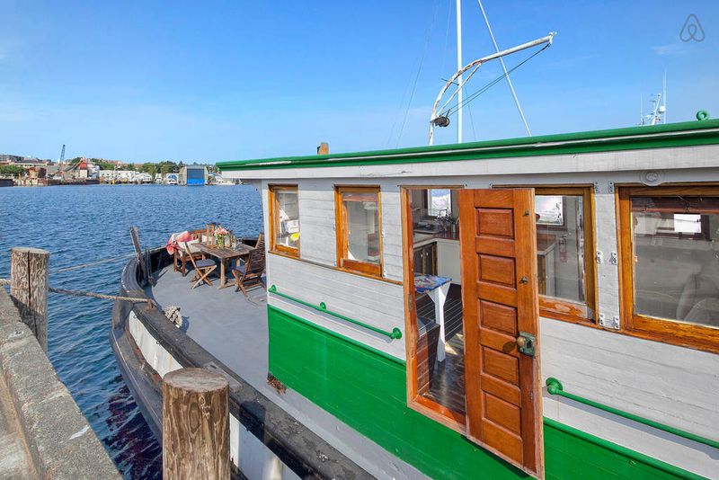 A white, tugboat-style houseboat with green trim